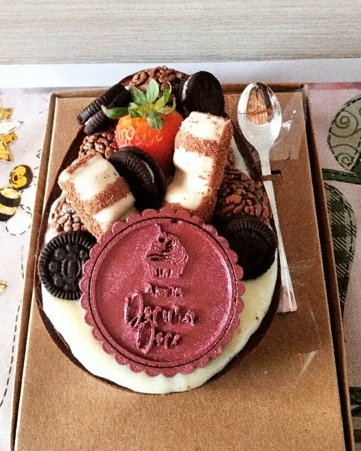 Bolo decorado com doces, biscoitos e mensagem Feliz Aniversário